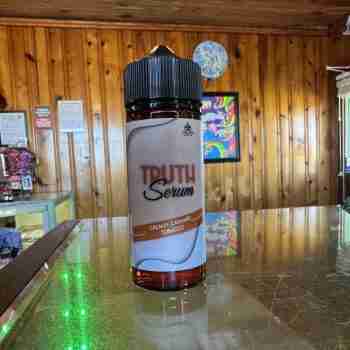 Bottle of Creamy Caramel Tobacco premium nicotine-free e-liquid with vanilla custard and tobacco flavor, 70% VG/30% PG